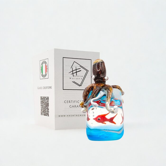 Scultura artigianale in vetro di Murano, modellata a lume senza stampi: un piccolo acquario con polpo in rilievo e pesce rosso immerso in un fondale blu. Un pezzo unico per veri amanti dell’arte del vetro 🇮🇹 Miniatura in vetro di Murano con spedizione gratuita in Europa.