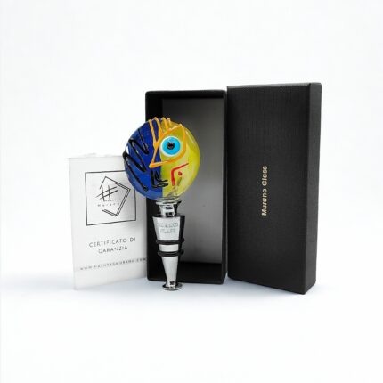 Tappo artistico in vetro di Murano lavorato a lume. Un volto diviso tra sole e notte per dare stile e poesia a ogni bottiglia. Made in Italy. Scatola rigida e certificato di garanzia.