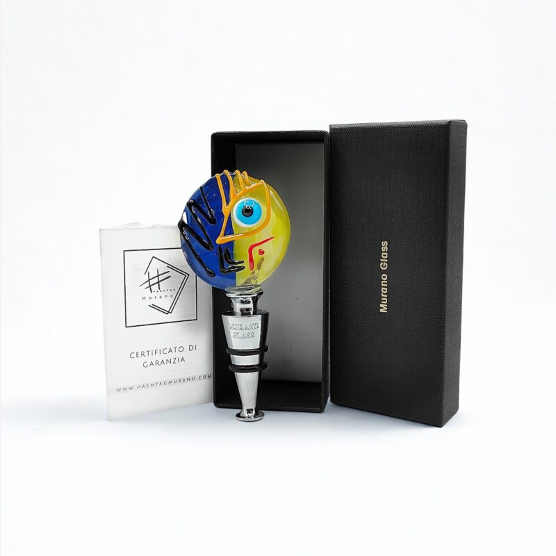 Tappo artistico in vetro di Murano lavorato a lume. Un volto diviso tra sole e notte per dare stile e poesia a ogni bottiglia. Made in Italy. Scatola rigida e certificato di garanzia.