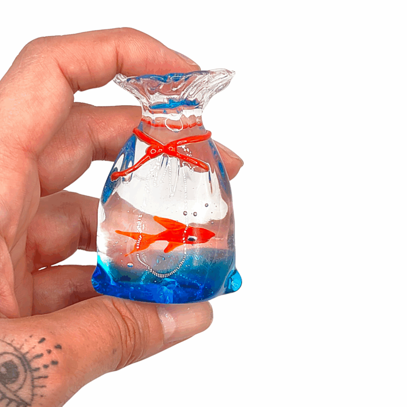 Miniatura in vetro di Murano che raffigura un peciolino rosso che nuota in un sacchetto trasparente