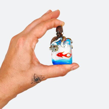 Scultura artigianale in vetro di Murano, modellata a lume senza stampi: un piccolo acquario con polpo in rilievo e pesce rosso immerso in un fondale blu. Un pezzo unico per veri amanti dell’arte del vetro 🇮🇹 Miniatura in vetro di Murano con spedizione gratuita in Europa.
